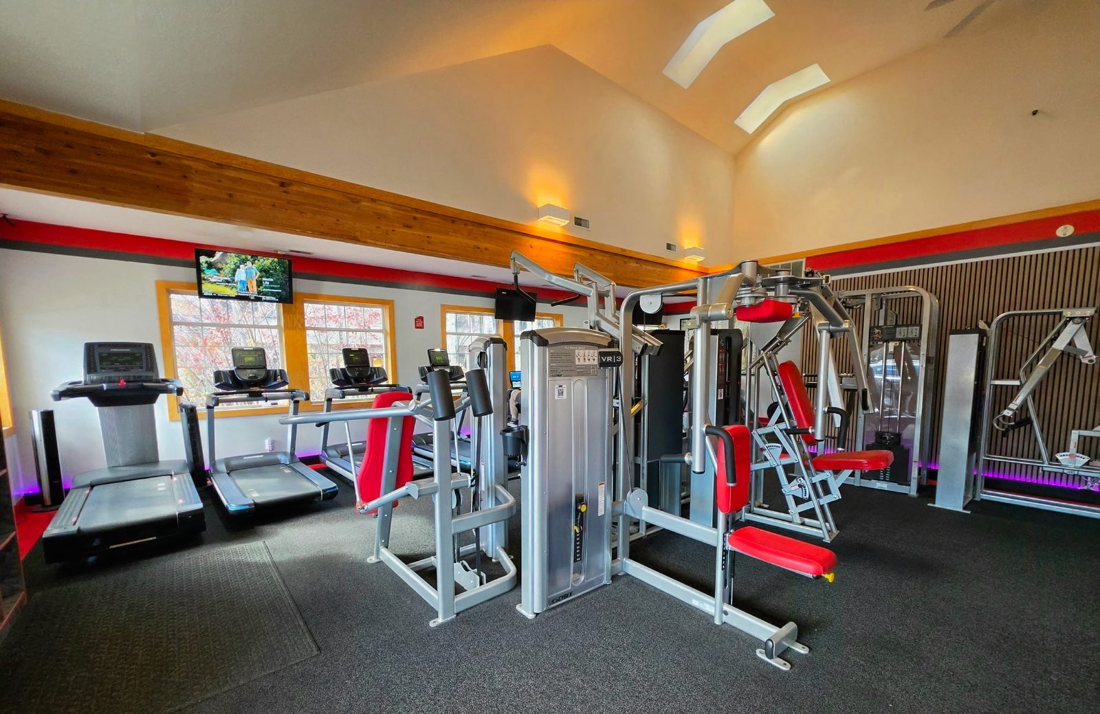 Treadmills and strength machines under a vaulted ceiling