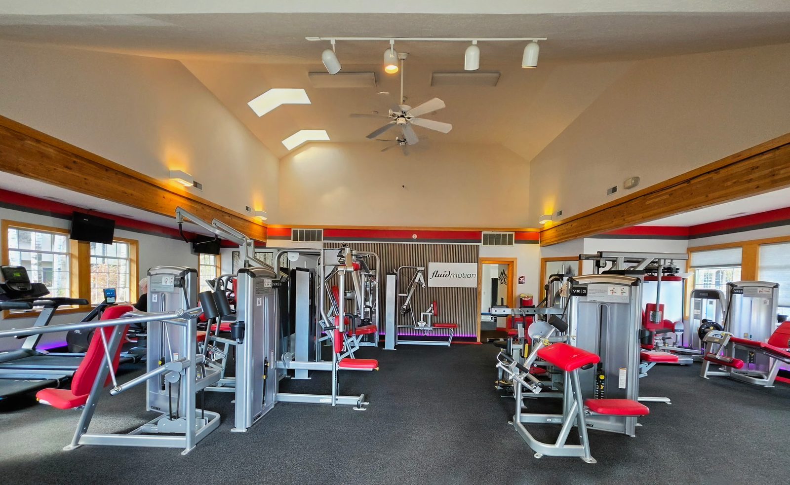 Wide view of the gym floor with the Fluid Motion sign