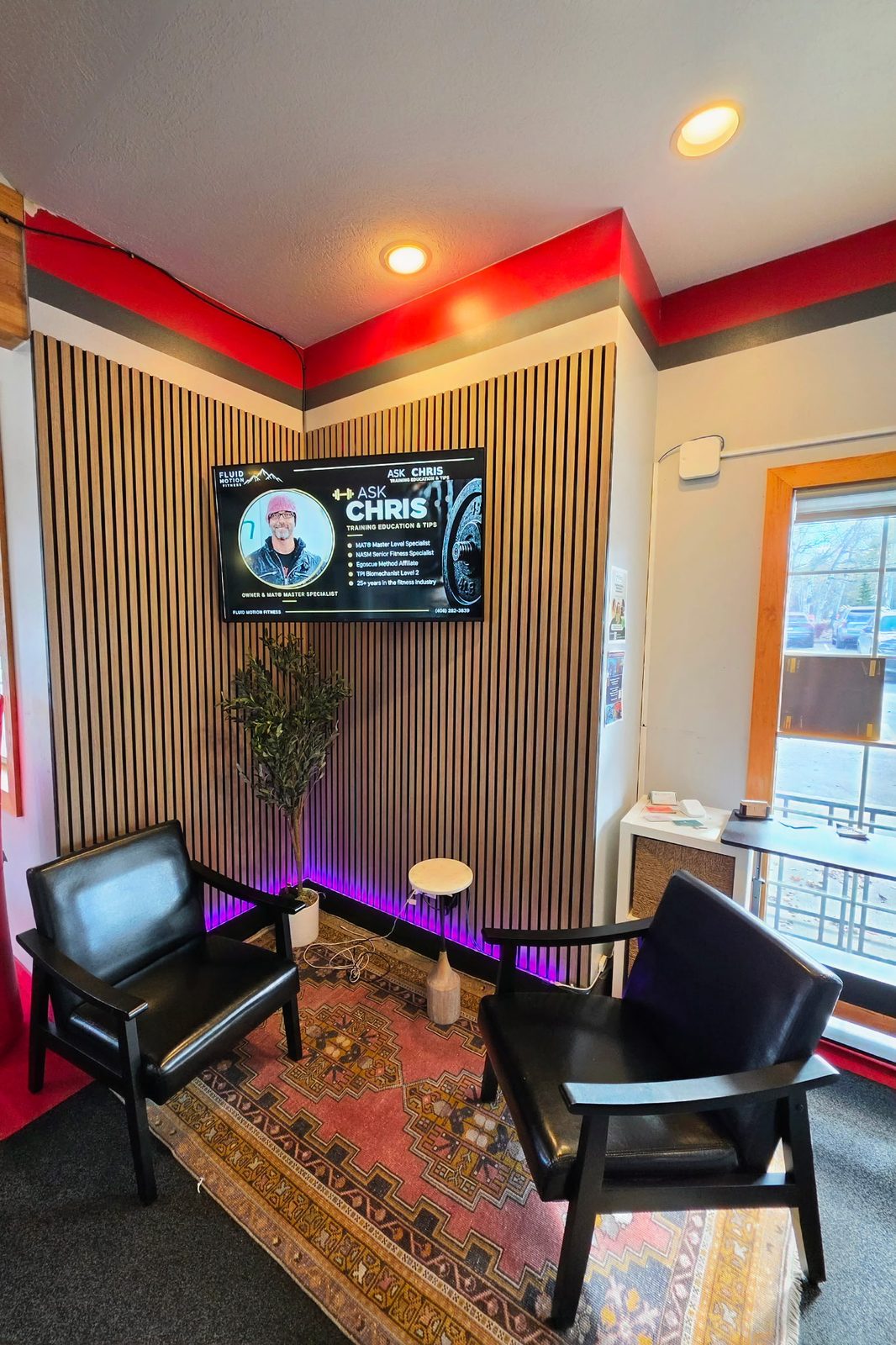 Lounge corner with a screen showing Ask Chris training tips