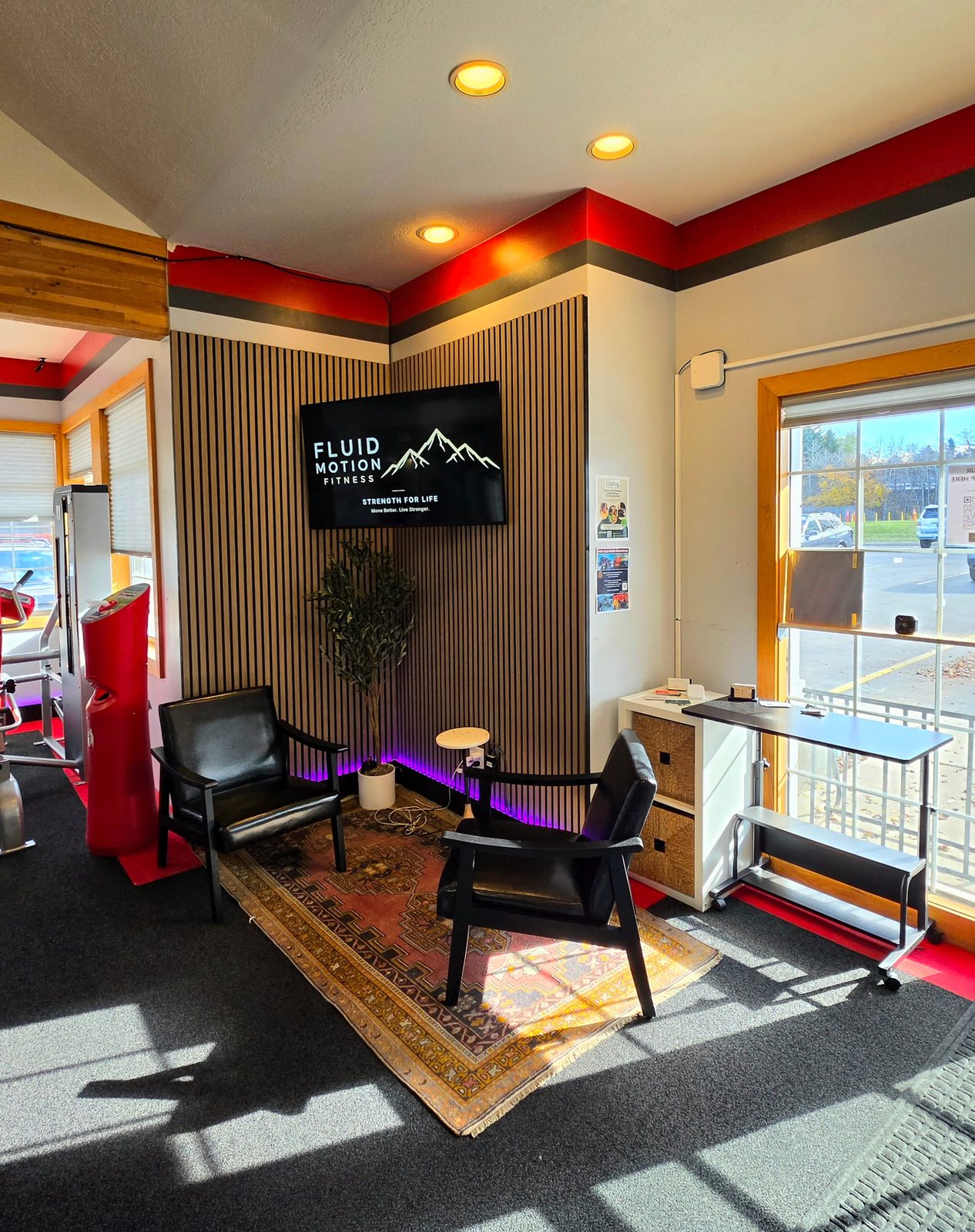 Lounge corner with leather chairs and a Fluid Motion Fitness sign